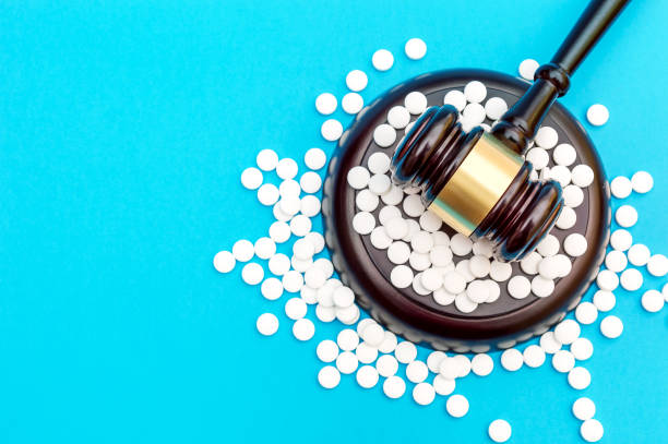 Gavel with white pills on blue. Top view. Space for text. Medical concept. stock photo