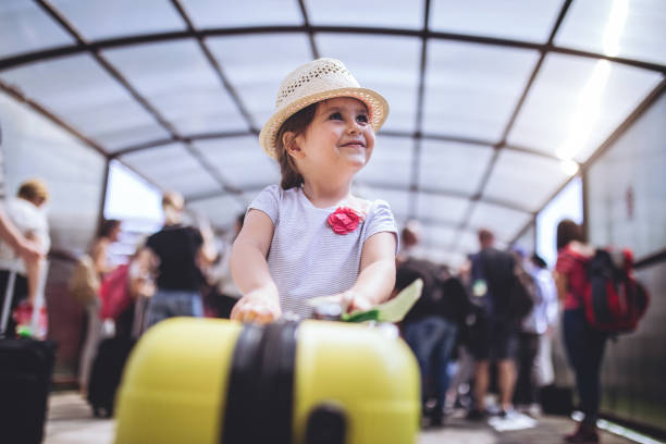 веселый и возбужденный малыш с ее казной в аэропорту - борт отъезда прибытия стоковые фото и изображения
