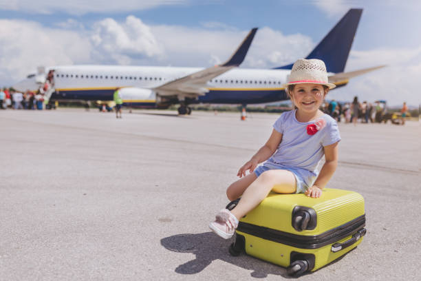 istock Gorgeous toddler sitting on a coffer before boarding a plane 992993332