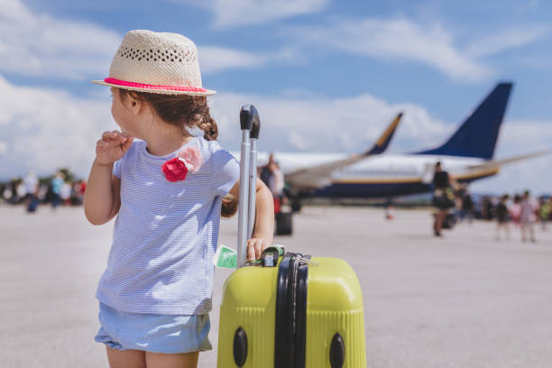 istock Young toddler girl standing before the plane with her coffer 992996828