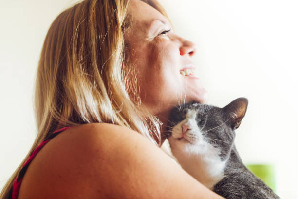 istock Young woman cuddling with her cat indoors 993002832