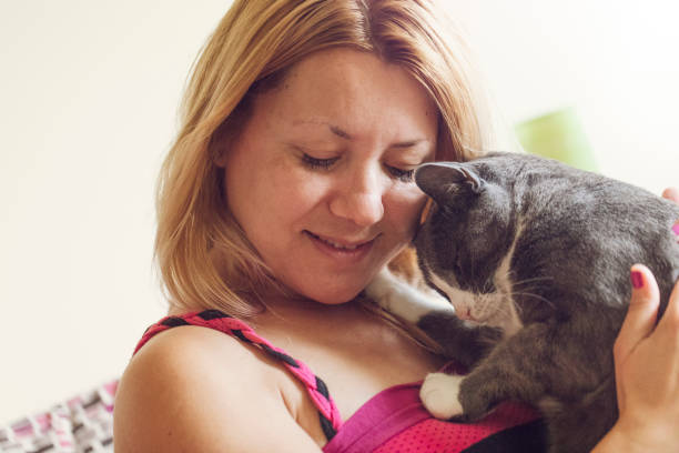 istock Young woman cuddling with her cat indoors 993003282
