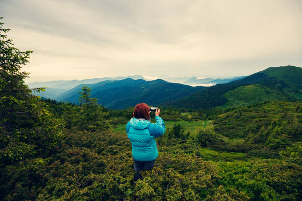 istock Adventurer female making a photo using a smartphone 993017282