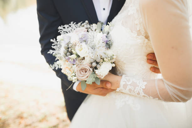 istock Newly married couple running and jumping in park while holding hands 993020492