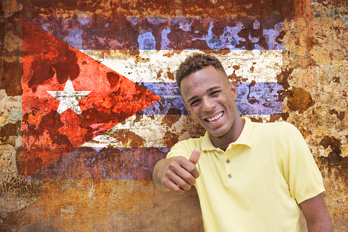 Cuban man giving Ok sign in Cuba Old Havana with cuban flag
