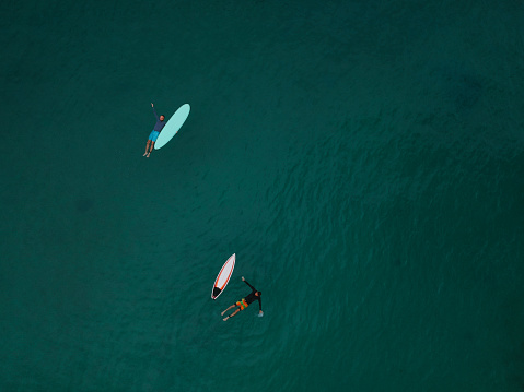 Aerial view of two surfers waiting for the wave
