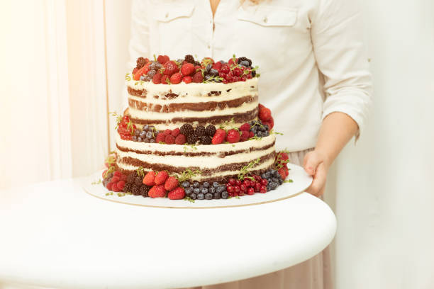 istock Wedding cake in two tiers with fresh berries holding 993117584
