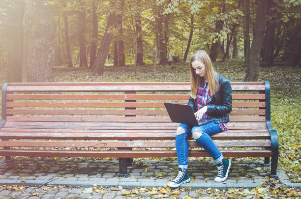istock Hipster girl use laptop in a park 993129948