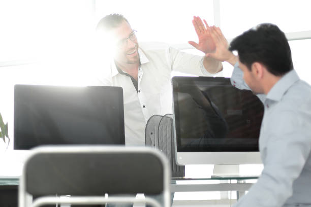 istock employees give each other a high five over the computer Desk 993137544