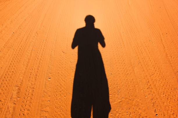 gites ombre sur chemin de terre orange, marron au milieu de nulle part dans l’outback australien - road long dirt footpath photos et images de collection