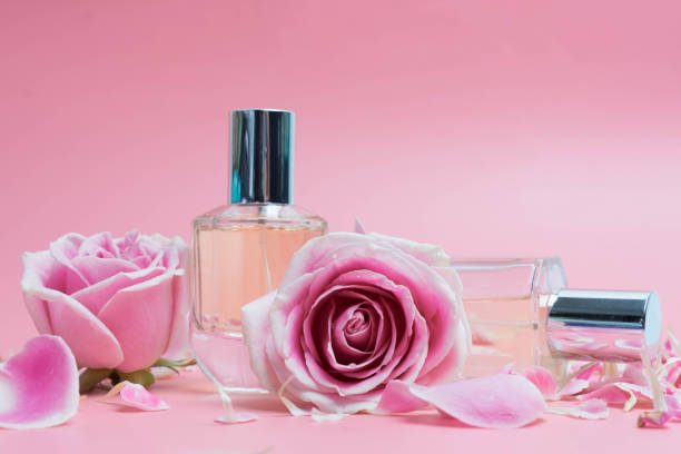 istock Beautiful perfume bottles  and rose on pink background 993186790