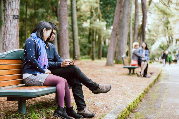 istock Lovers who sit on a bench and have intimate time at a fresh green park 993267200