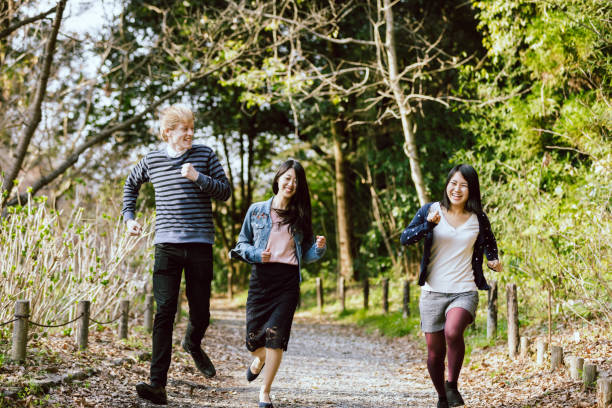 istock Three multinational lovers and friends running happily in a fresh green park 993267454
