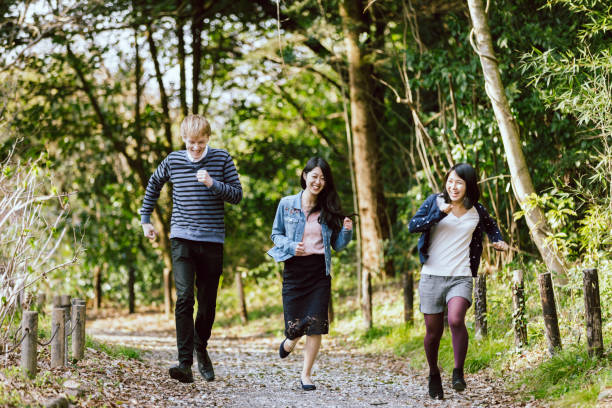 istock Three multinational lovers and friends running happily in a fresh green park 993267458