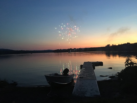 Fireworks by the lake at sunset on July 4th
