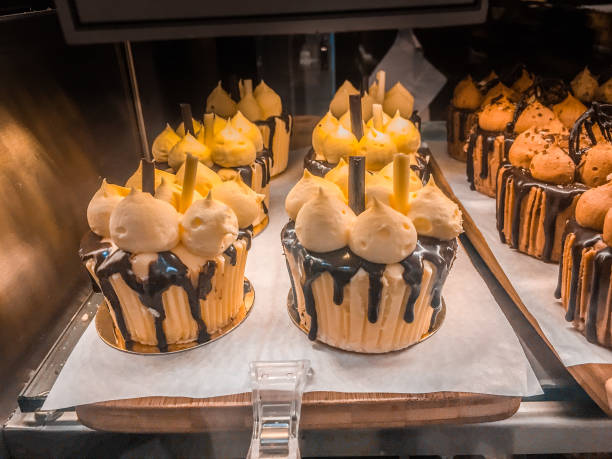 istock Rows of delicious cupcakes displayed in cafe storefront window 993330358