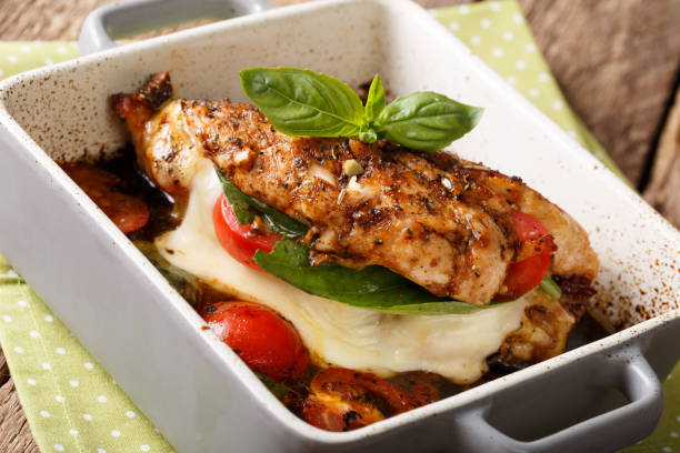 istock Balsamic chicken fillet baked with mozzarella, basil and tomatoes close-up in a baking dish. horizontal 993350314