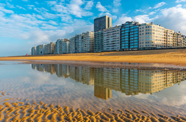 Reflection of the urban skyline of Ostend in the North Sea with its waterfront and apartment buildings, Belgium, Europe.
