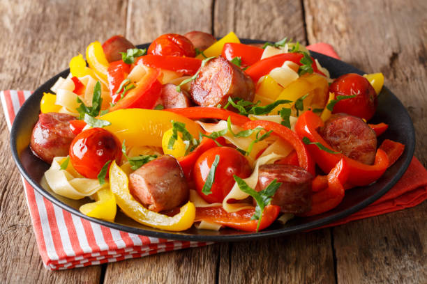 fettuccine di pasta con peperone e salsicce da vicino. orizzontale - pepper bell pepper portion vegetable foto e immagini stock