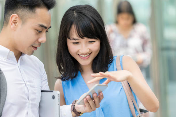 istock Smiling woman and husband use smart phone 993354116