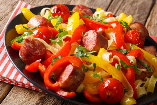 istock Noodles with stewed bell pepper and sausages close-up. Horizontal 993354174
