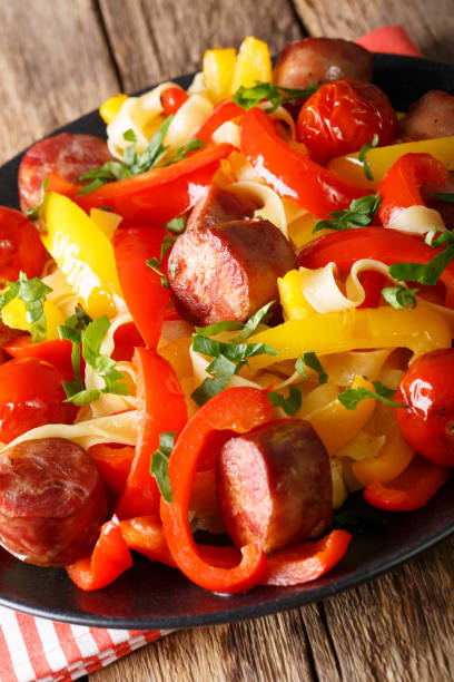 istock Stewed pepper with sausages and noodles closeup. Vertical 993358626