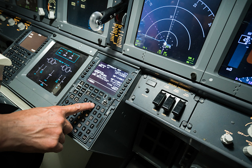 Pilot pushing buttons in the cockpit