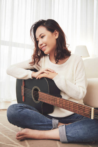 istock Dreamy girl enjoying playing guitar 993381082