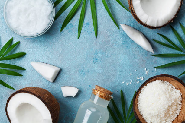 fundo azul com um conjunto de produtos de coco orgânico para spa tratamento, cosmético ou alimentos ingredientes. óleo, água e aparas de vista superior. plano de leigos. - turquoise blue spa treatment green - fotografias e filmes do acervo