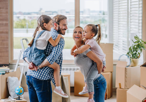 istock Happy family talking and piggybacking while moving into new apartment. 993401916