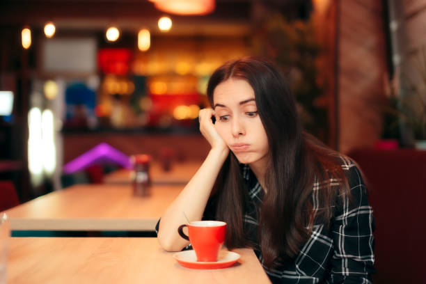 コーヒー ショップで彼女の日付を待っている退屈少女 - stood up ストックフォトと画像