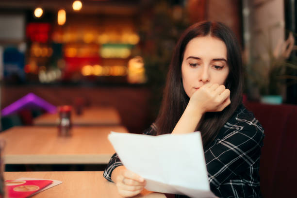 Woman Reading Documents in a Coffee Shop Girl analyzing a contract after just signing it read the fine print stock pictures, royalty-free photos & images