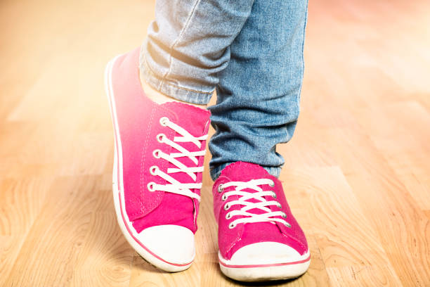 istock Ankles wearing jeans and brught pink sneakers 993404996