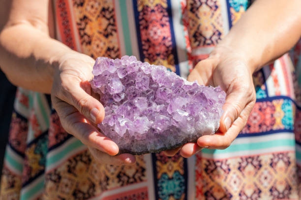 uma mulher em um vestido, segurando um lindo pedaço de ametista cristal grande - amethyst necklace gem purple - fotografias e filmes do acervo