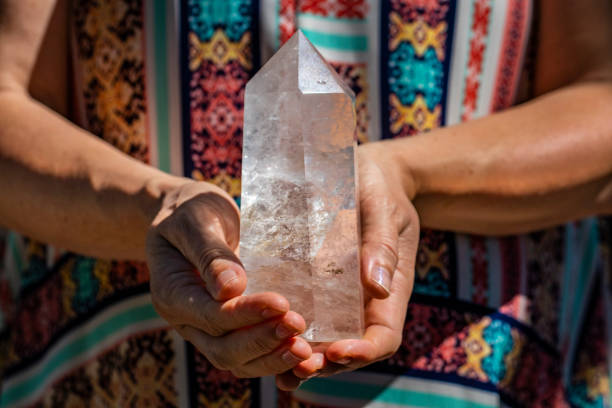 женщина в платье проведения красивый большой кусок кварцевого кристалла - chakra crystal recovery spirituality стоковые фото и изображения