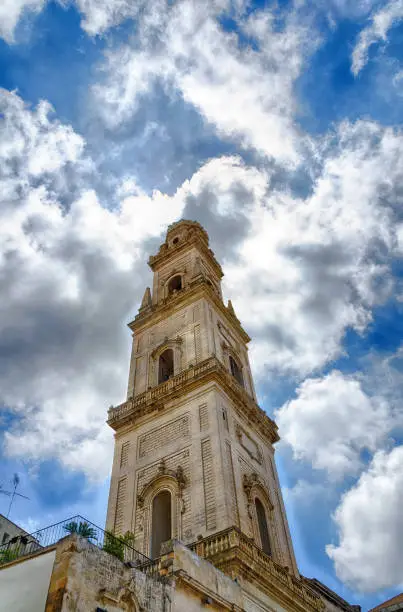 blue sky with glowing clouds and the tower of the cathedral of Lecce, Italy