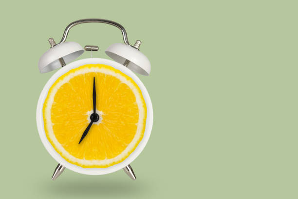 istock Creative fresh lime slice alarm clock on pastel green background, idea concept 993431794