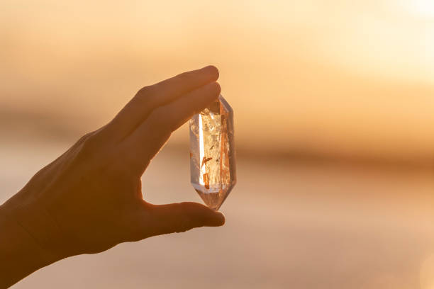 istock A hand holding up a beautiful quartz crystal outdoors in the sun 993437646