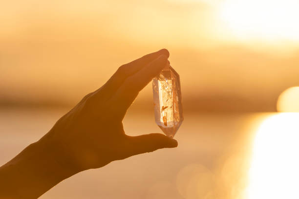 istock A hand holding up a beautiful quartz crystal outdoors in the sun 993437670