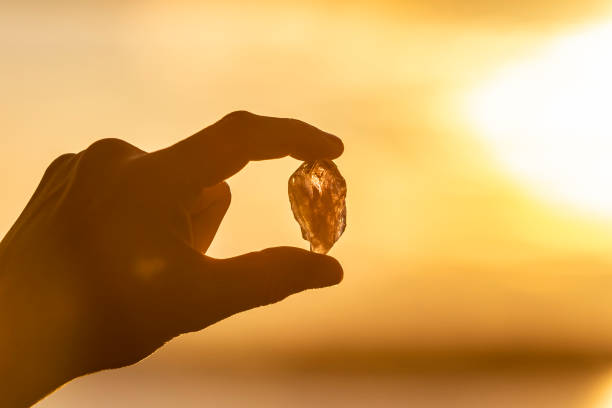 istock A hand holding up a beautiful Amethyst crystal outdoors in the sun 993437770