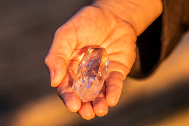 istock A hand holding up a beautiful quartz crystal outdoors in the sun 993437822