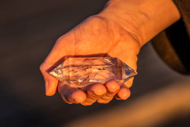 istock A hand holding up a beautiful quartz crystal outdoors in the sun 993437946
