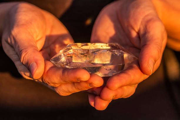 mains tenant un cristal de quartz bel à l’extérieur au soleil - transparent crystal crystal ball human hand photos et images de collection