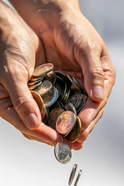 istock A Hand Holding and Dropping Coins 993442958