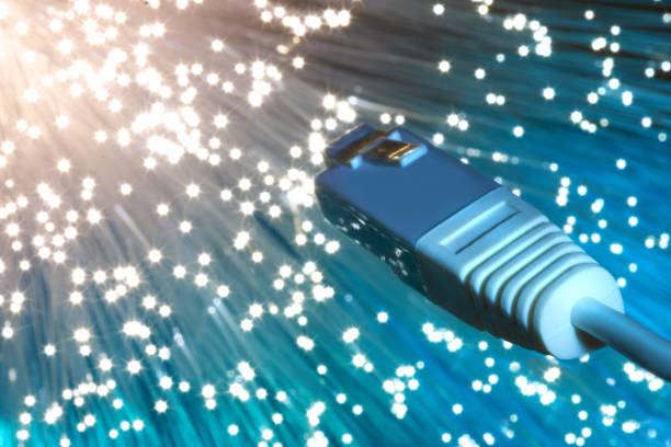 istock Closeup on the end of optical fiber network cable on blue background 993444472