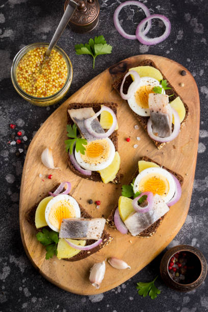 istock Sandwich on bread with herring, potatoes, egg, onion, tasty appetizer with mustard 993457472