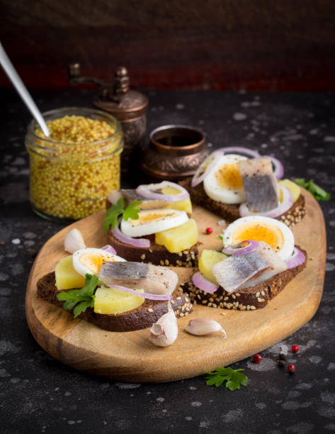 istock Sandwich on bread with herring, potatoes, egg, onion, tasty appetizer with mustard 993457558