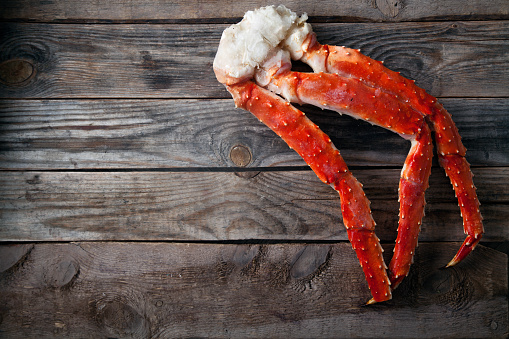 Fresh crab claws on vintage wooden background. Horizontal composition. Copy space for banner.