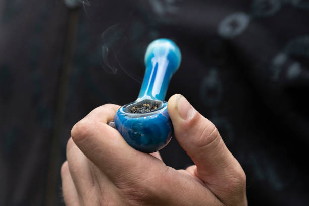 A Pipe Full of Marijuana in Someones Hand A Pipe Full of Marijuana in Someones Hand. pipe smoking pipe stock pictures, royalty-free photos & images