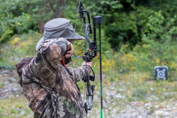 istock A Man Wearing Camouflage Shooting a Compound Bow at a Target 993466804